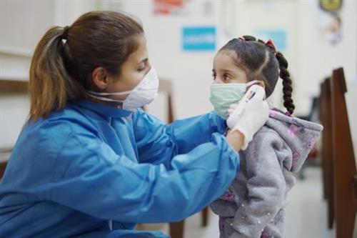Nurse helping child with mask 
